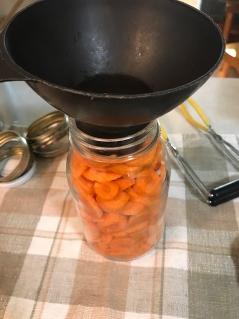 filling a quart jar with carrots