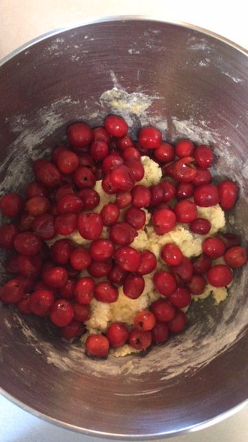 adding the cherries and almonds to the dough
