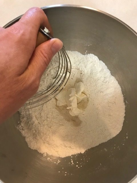 cutting the butter and cream cheese into the dry ingredients