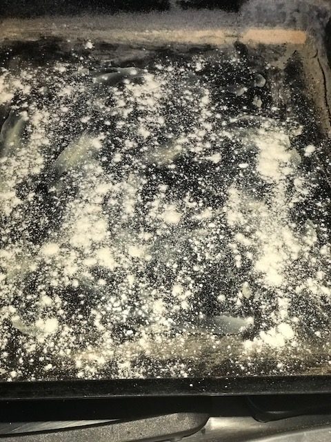 dusting a pan with flour
