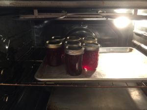 jars of strawberry jam warming in oven