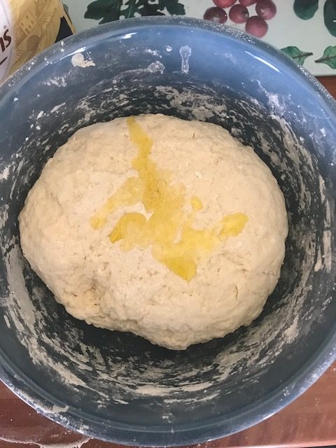 pouring olive oil over Sicilian bread dough
