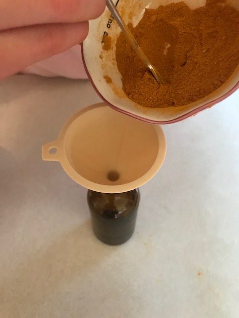 pouring turmeric, ginger, and pepper mixture into a jar