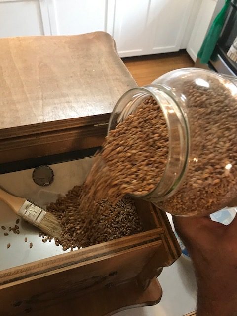 pouring wheat into the grinder
