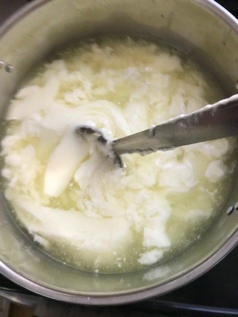 stirring the curd with an up and down motion