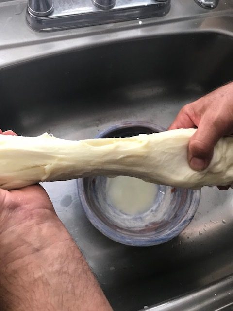 stretching the cheese like taffy