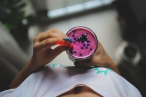 woman holding a blueberry smoothie